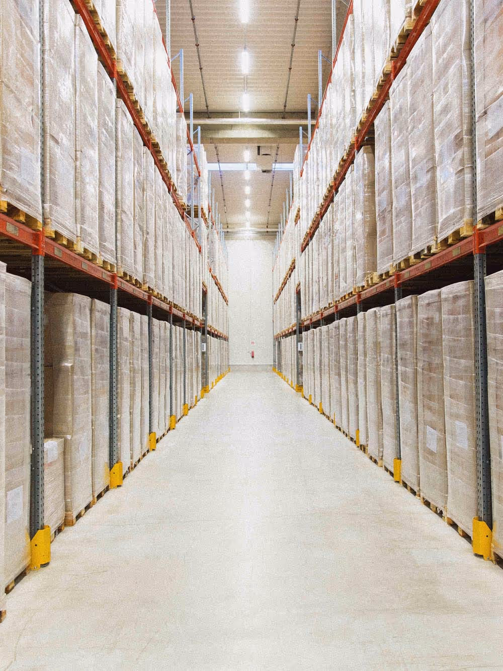 Aisle of a large warehouse with tall shelving